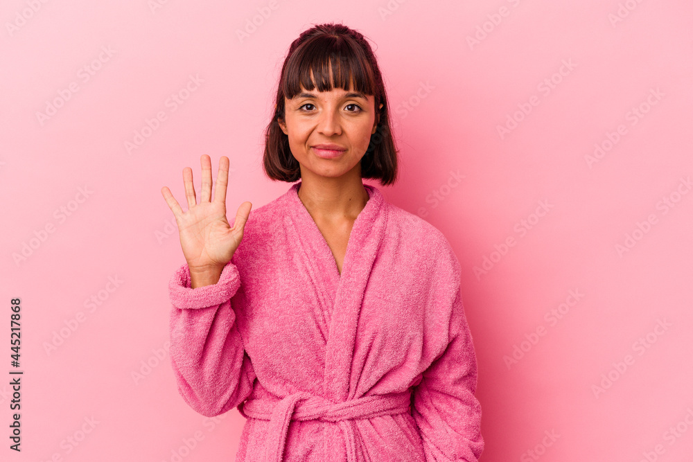 Young mixed race woman wearing a bathrobe isolated on pink background smiling cheerful showing number five with fingers. Young mixed race woman wearing a bathrobe isolated on pink background smiling cheerful showing number five with fingers.