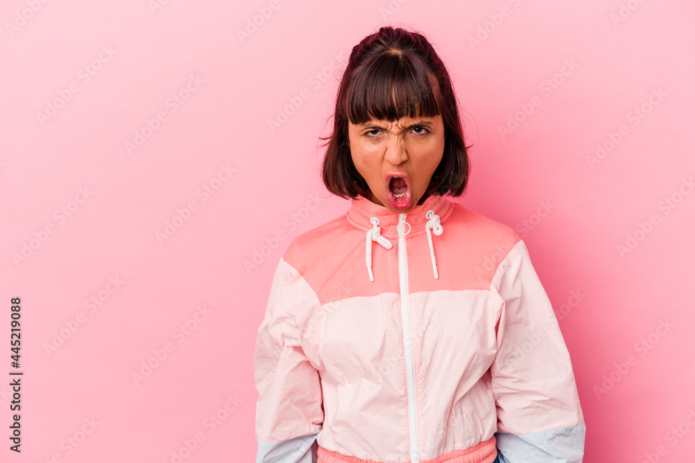 Young mixed race woman isolated on pink background shouting very angry, rage concept, frustrated. Young mixed race woman isolated on pink background shouting very angry, rage concept, frustrated.