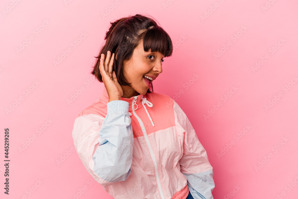 Young mixed race woman isolated on pink background trying to listening a gossip. Young mixed race woman isolated on pink background trying to listening a gossip.