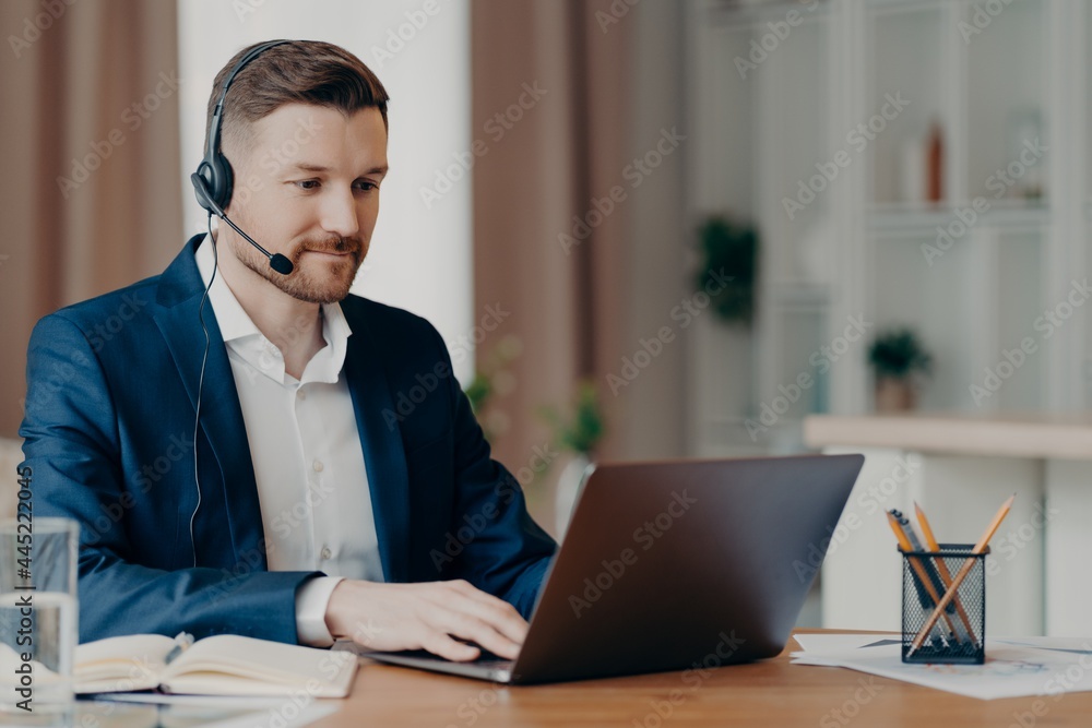 Attentive businessman looking at laptop screen while working from home Attentive businessman looking at laptop screen while working from home