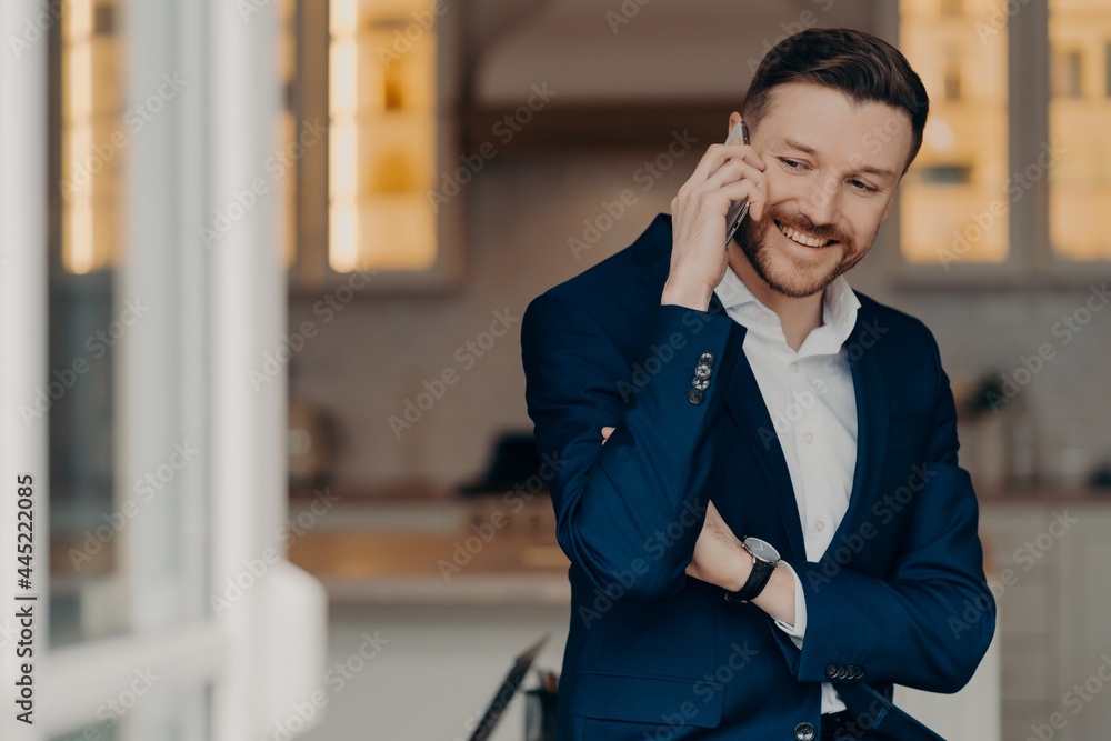 Happy executive director in stylish suit and with phone indoors Happy executive director in stylish suit and with phone indoors