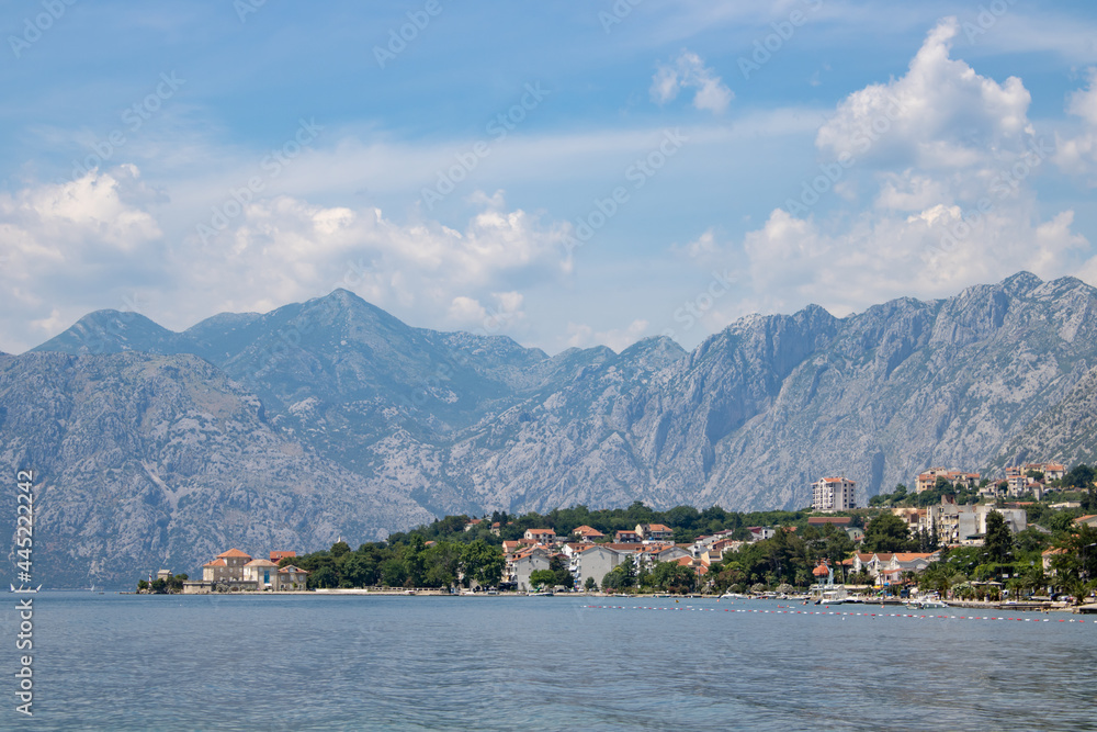 Landscape with blue sea and green mountains against the background of a clear sky. Panoramic beautiful view over the sunny city. Balkans on a wonderful summer day.