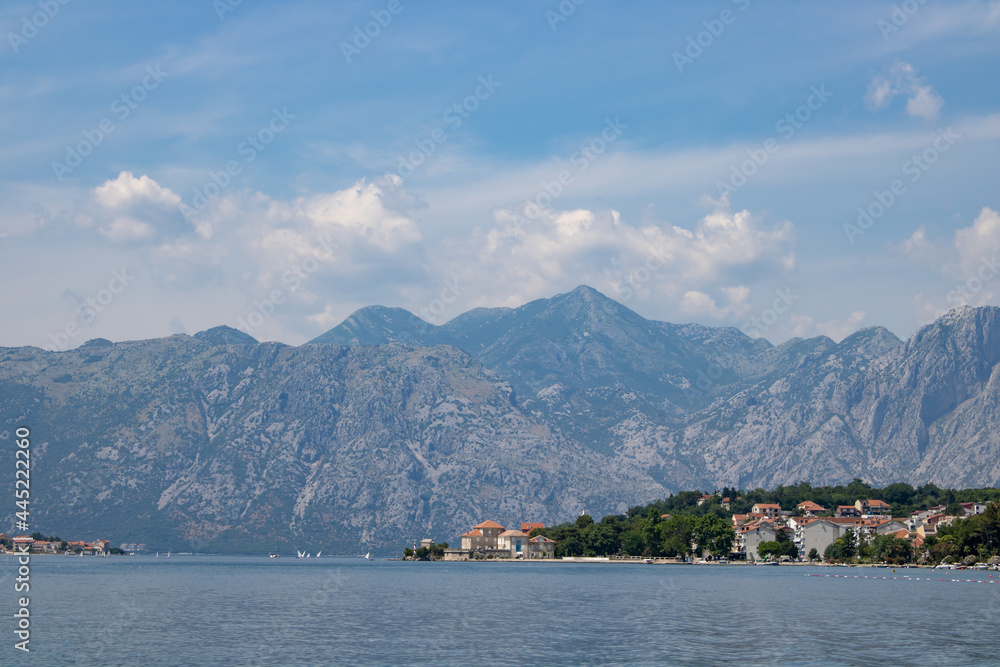 Landscape with blue sea and green mountains against the background of a clear sky. Panoramic beautiful view over the sunny city. Balkans on a wonderful summer day.