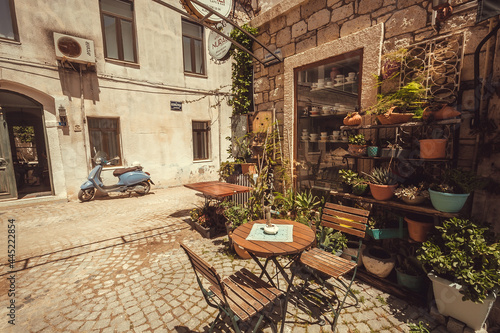 Small town restaurant in historical area and vintage scooter on narrow street