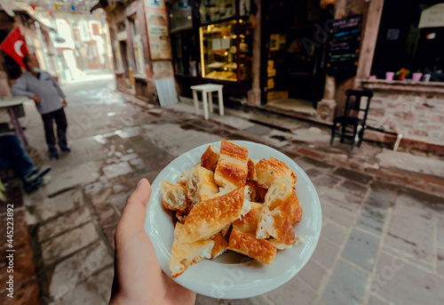 Fast food with turkish borek food, on street with people, some bars and small cafes photo