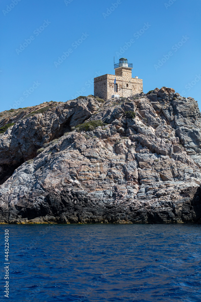 Lighthhouse building on a rocky cliff. Ios island Greece. Cyclades