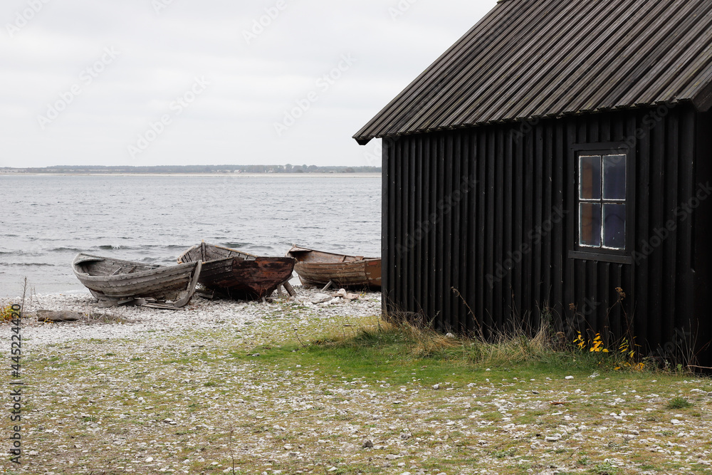 Old shed and boats at the historic Helgumannen fishing station located on the Faro island in the Swedish province of Gotland.