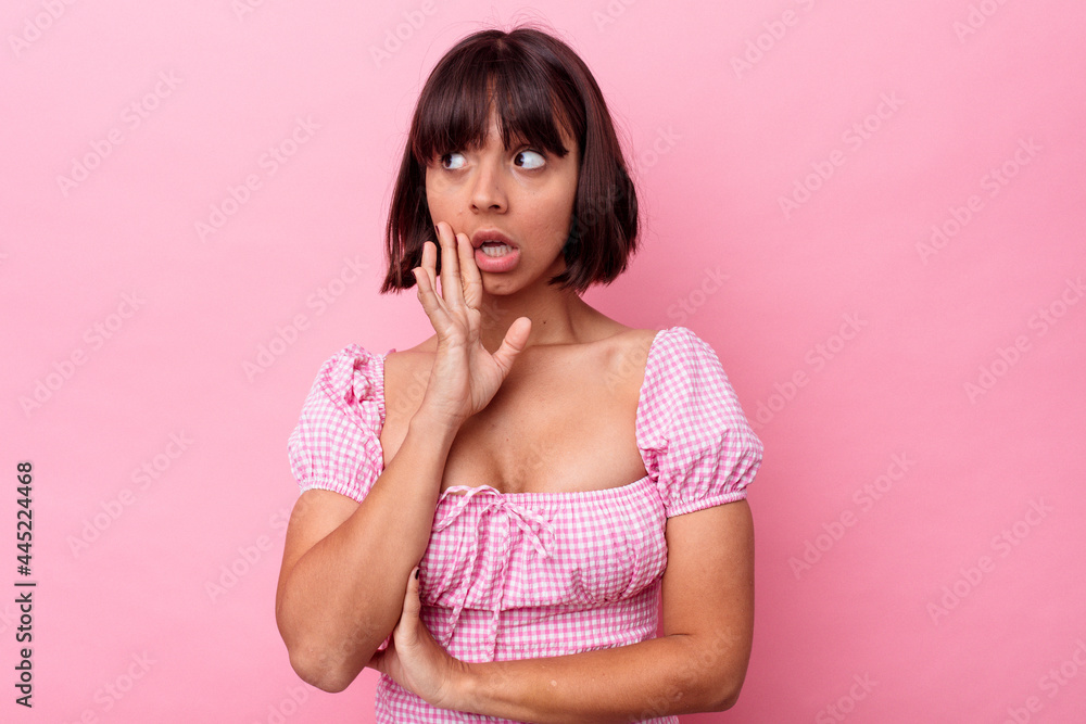 Young mixed race woman isolated on pink background is saying a secret hot braking news and looking aside Young mixed race woman isolated on pink background is saying a secret hot braking news and looking aside