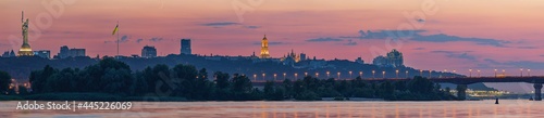 Foto View of the Kiev-Pechersk Lavra, Kiev bridges and the Dnieper River, after sunset, a thin crescent moon is seen in the pink sky