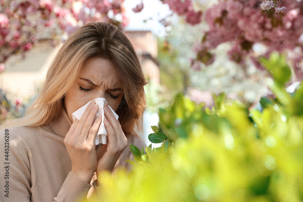 Woman suffering from seasonal pollen allergy outdoors - obrazy, fototapety, plakaty 