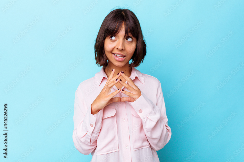 Young mixed race woman isolated on blue background making up plan in mind, setting up an idea. Young mixed race woman isolated on blue background making up plan in mind, setting up an idea.