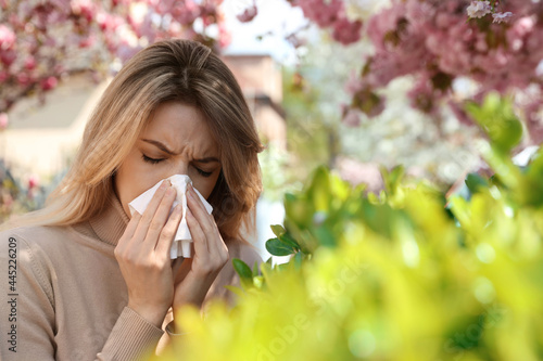 Woman suffering from seasonal pollen allergy outdoors photo