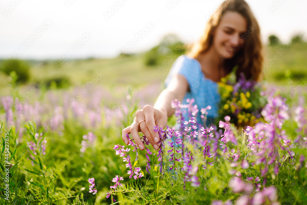 Young woman in stylish summer dress feeling free in the field with flowers in sunshine. Nature, vacation, relax and lifestyle. Summer landscape. Young woman in stylish summer dress feeling free in the field with flowers in sunshine. Nature, vacation, relax and lifestyle. Summer landscape.