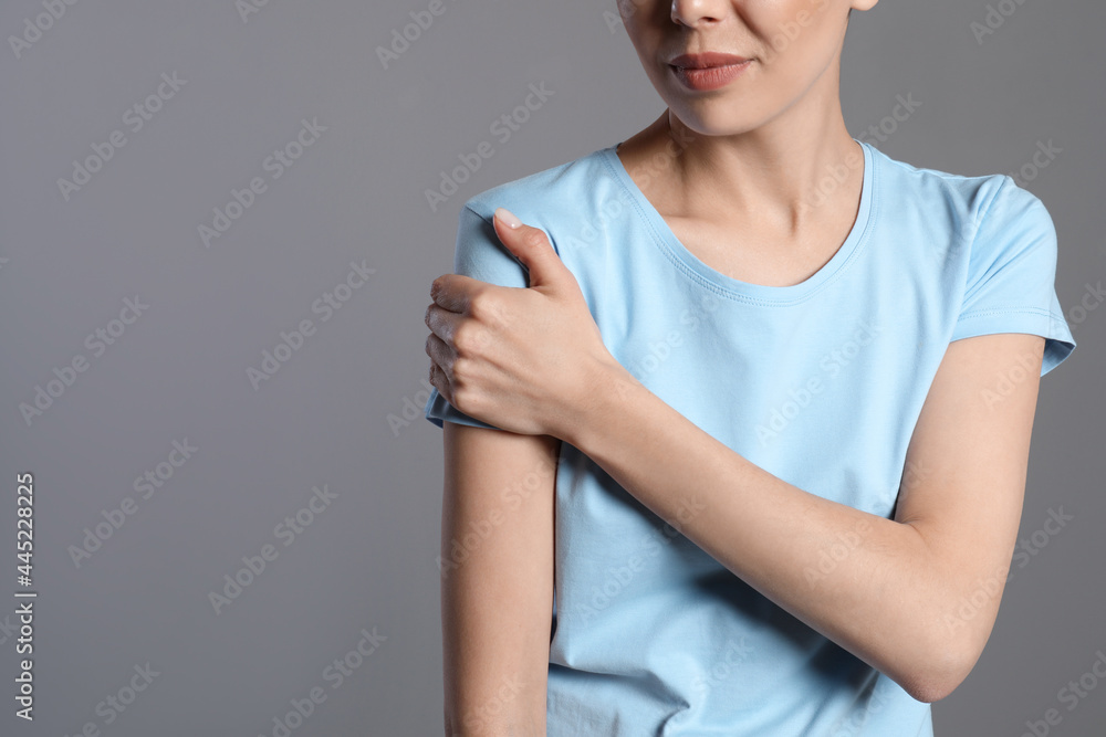 Woman suffering from shoulder pain on beige background, closeup. Space for text Woman suffering from shoulder pain on beige background, closeup. Space for text