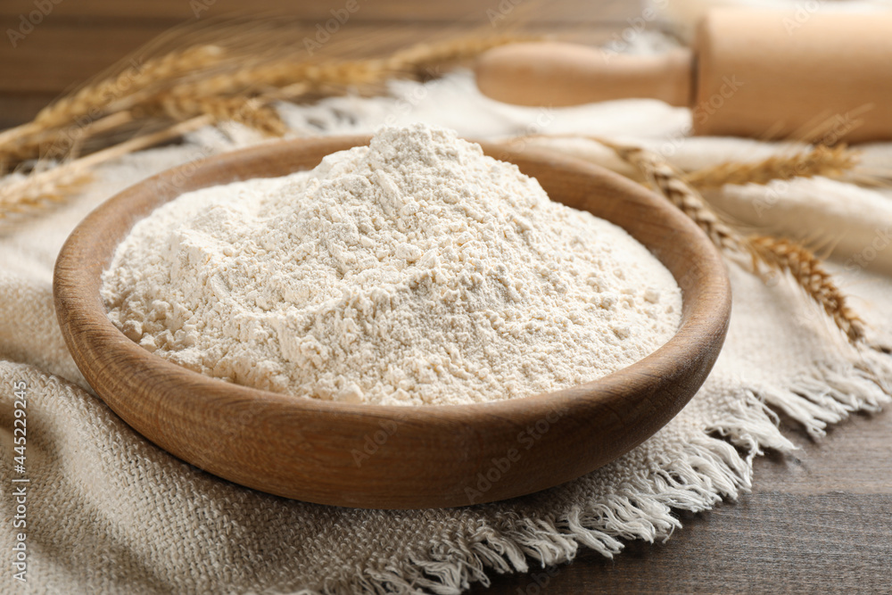 Bowl with wheat flour on wooden table, closeup Bowl with wheat flour on wooden table, closeup