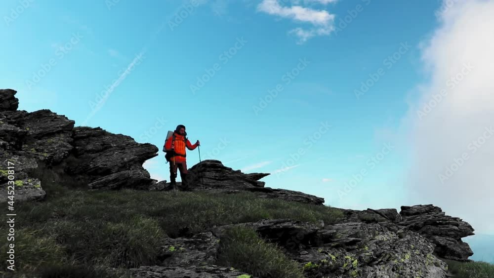 A hiker walking alone on mountain at high altitude A hiker walking alone on mountain at high altitude