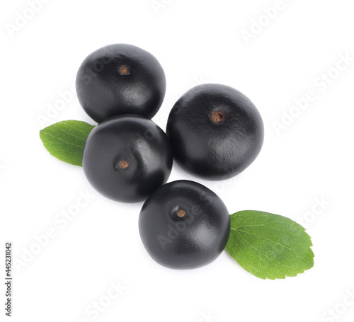 Pile of fresh ripe acai berries and green leaves on white background, top view
