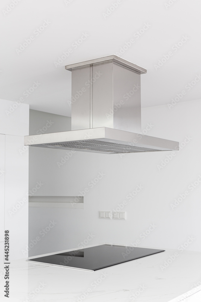 Cooker hood and electric stove of a modern and minimalist kitchen Cooker hood and electric stove of a modern and minimalist kitchen
