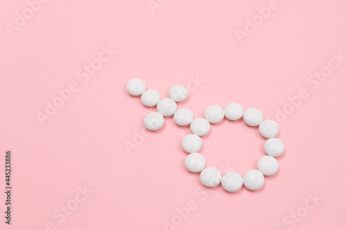 Female Gender Symbol Made from White Pills - Women's Health and Medicine, Medicaments for Women, Lying on Pink Background. Copy Space