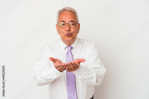 Senior american man isolated on white background folding lips and holding palms to send air kiss.