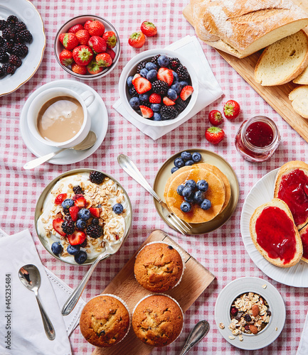 BIG BREAKFAST with blueberry pancake, bread, coffee, muffin, yoghurt, fruits ON A RED SQUATE TABLECLOTH