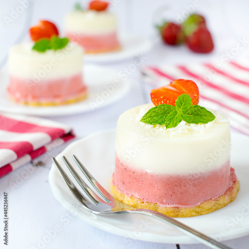 Mini coconut and strawberry cheesecakes. Monoportions of summer dessert with coconut, white chocolate and fresh strawberries. photo