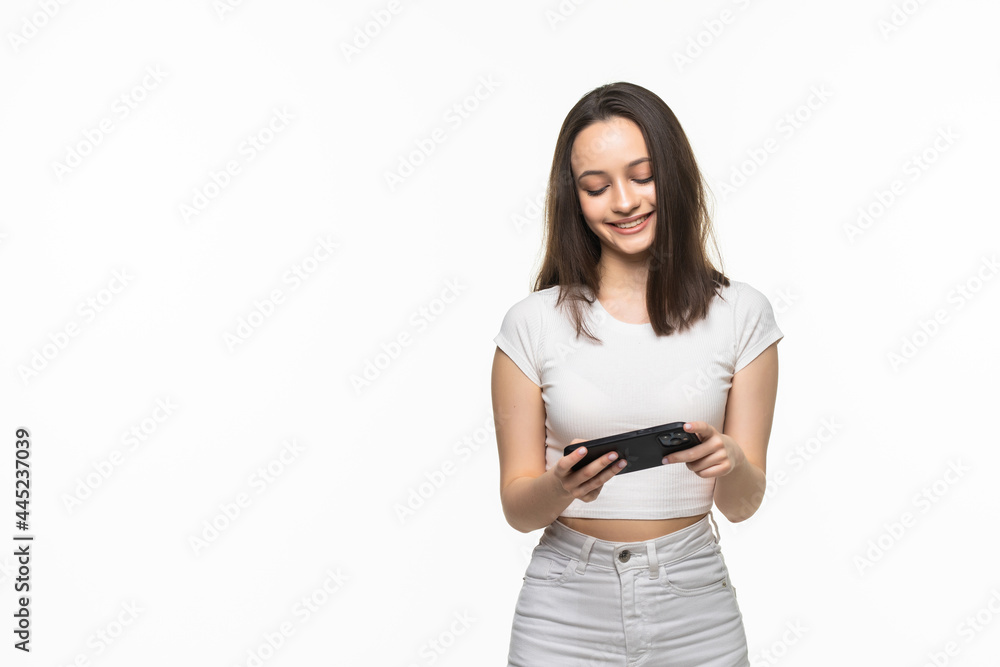 Photo of emotional young caucasian woman play games by phone. Looking aside. Photo of emotional young caucasian woman play games by phone. Looking aside.