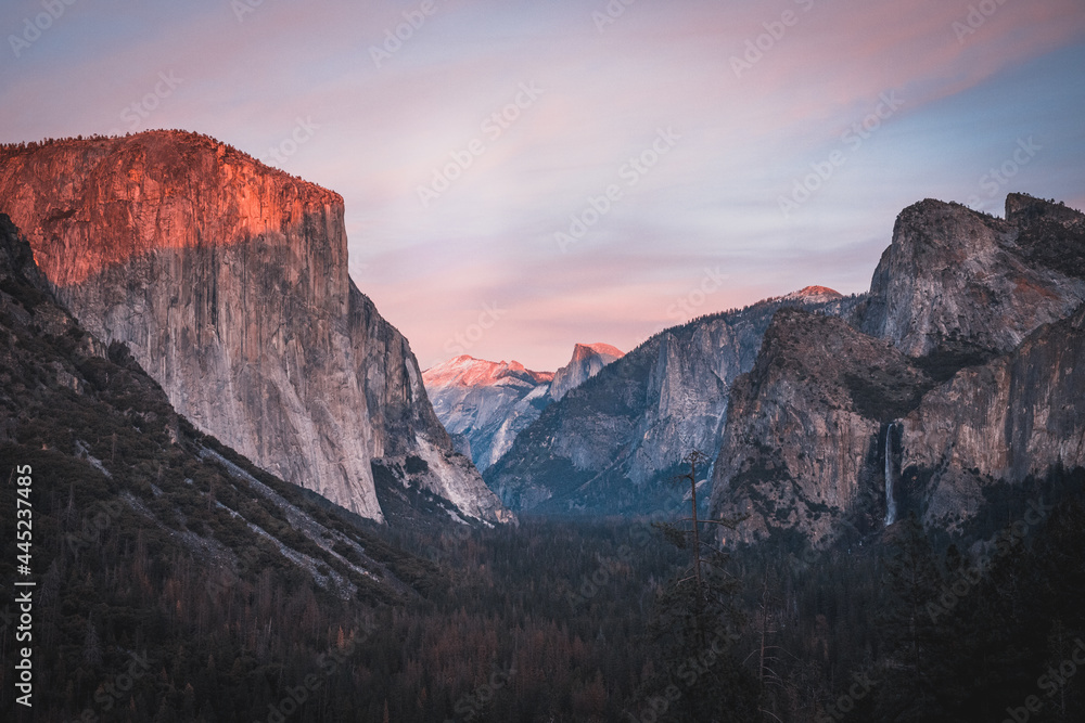 Yosemite National Park Tunnel View overlook at sunset. Front view panorama of popular El Capitan and Half Dome at deep red sunset.