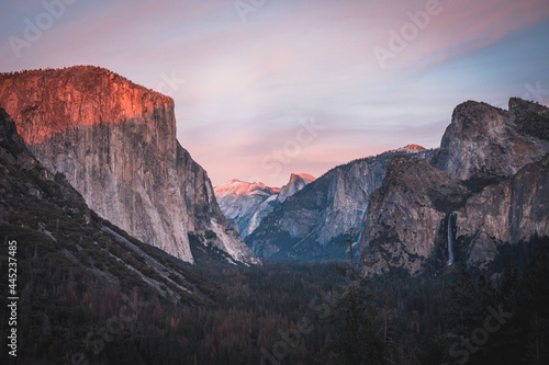 Yosemite National Park Tunnel View overlook at sunset. Front view panorama of popular El Capitan and Half Dome at deep red sunset.