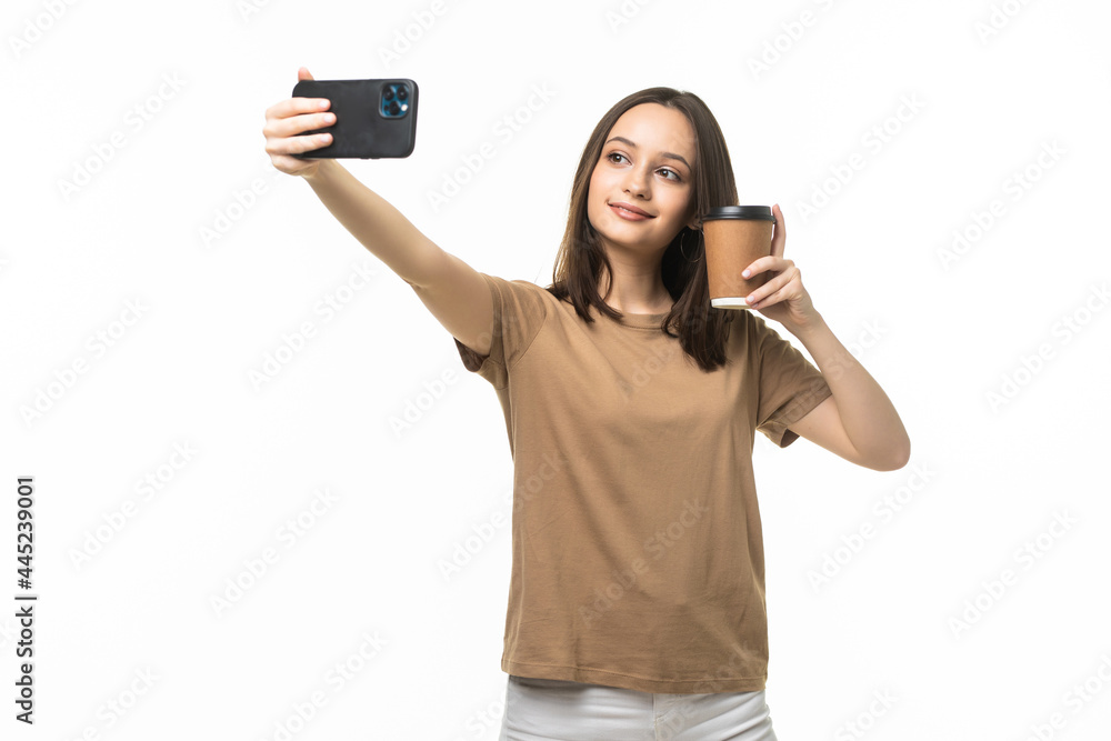 Young beautiful woman using smartphone selfie time, holding coffee cup and mobile phone Isolated on white background. Young beautiful woman using smartphone selfie time, holding coffee cup and mobile phone Isolated on white background.