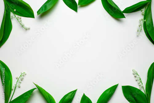 Small bouquets of lilly of the valley as a floral frame with copy space. Top view with white background. 