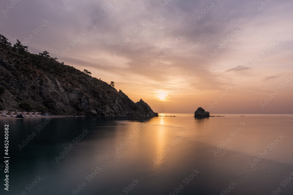 Picturesque Mediterranean seascape in Turkey. Colorful sunrise in a small bay near the Tekirova village, District of Kemer, Antalya Province. Long exposure photo.