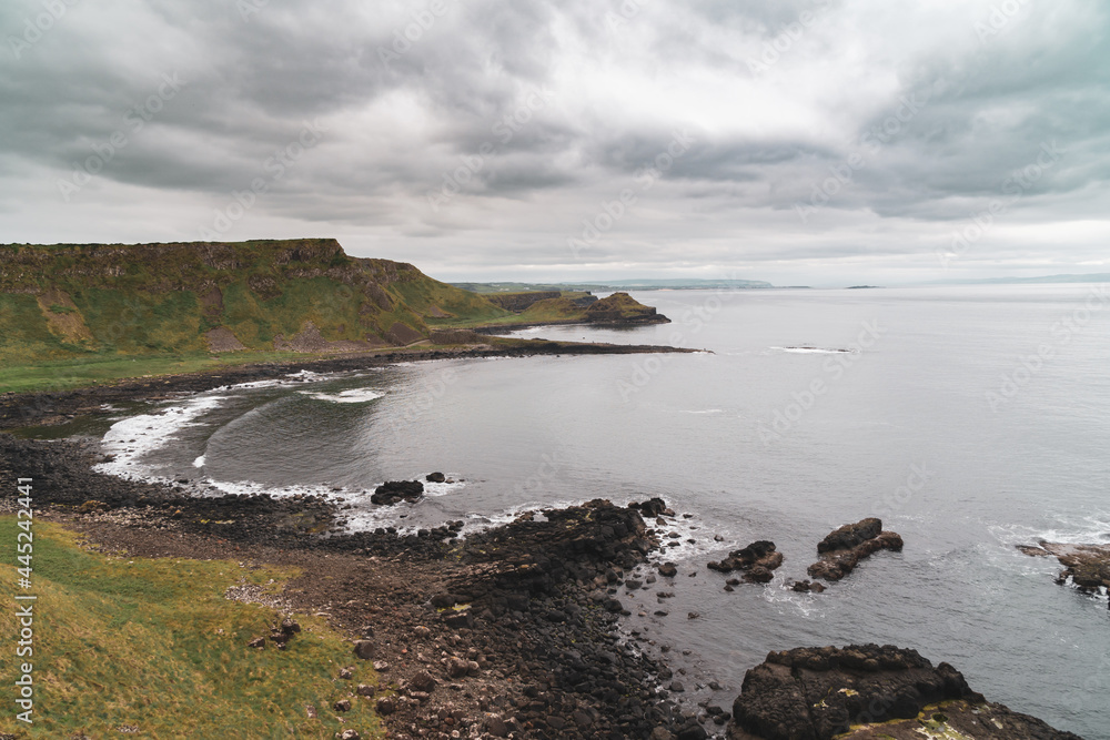 Giant's Causeway basalt rocks pattern in a beautiful summer day, Northern Ireland. The nature hexagon stones result of an ancient volcanic fissure eruption. Giant's Causeway basalt rocks pattern in a beautiful summer day, Northern Ireland. The nature hexagon stones result of an ancient volcanic fissure eruption.