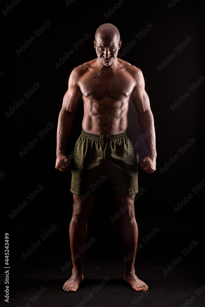 Muscular adult male standing looking at camera with serious expression