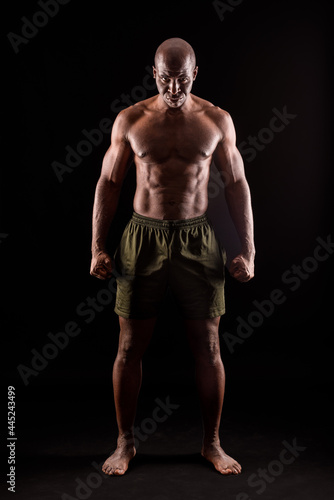 Muscular adult male standing looking at camera with serious expression
