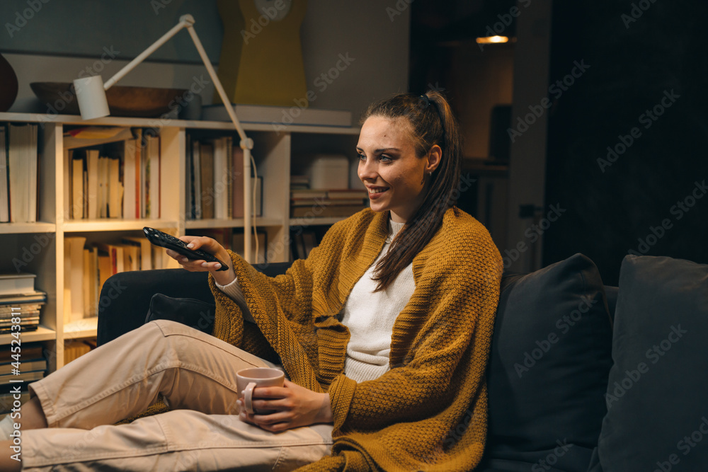 Fototapeta premium woman relaxing at home watching television. evening scene