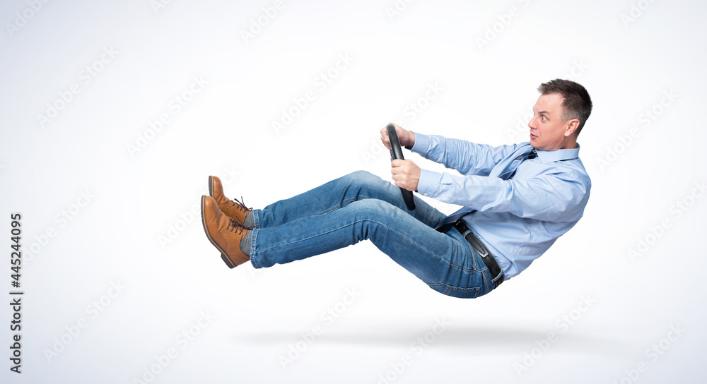 Emotional man in jeans, shirt and tie maneuvers a car while holding a car steering wheel. Safe driving concept. Emotional man in jeans, shirt and tie maneuvers a car while holding a car steering wheel. Safe driving concept.