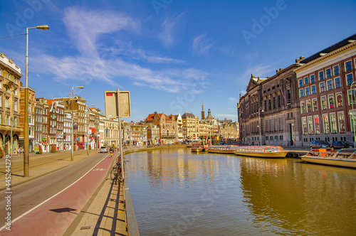 Cityscape with old and modern architecture, tourists and local people in historical downtown of Amsterdam, Netherlands.