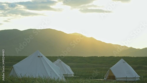 Eco touristic glamping camp large tents in wild meadow in spring