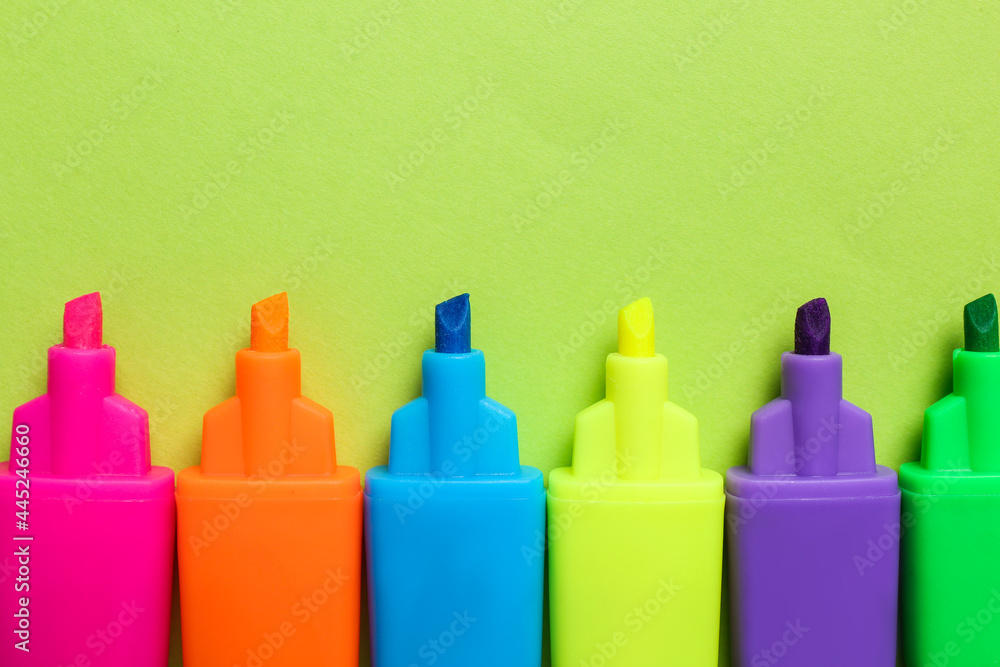 Set of highlighters on light green background, flat lay Set of highlighters on light green background, flat lay