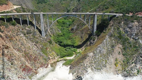Aerial view of Bixby Bridge in Big Sur State Park in California. Vegetation and ocean waves can be seen along the coastline on Highway 1.