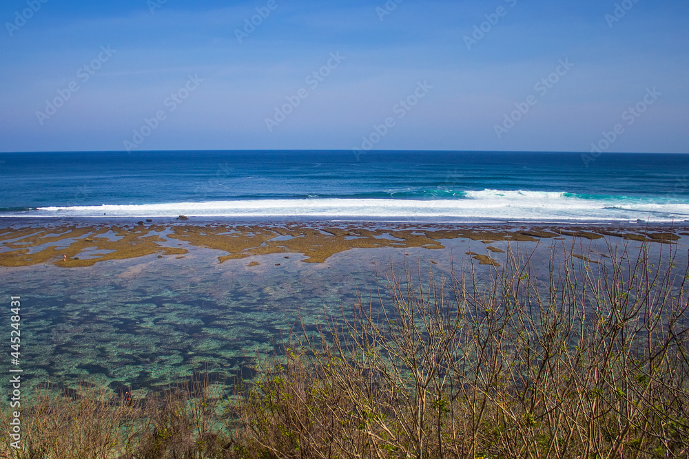 Aerial view of Gunung Payung Beach at low tide, Bali, Indonesia. Beautiful secret beach with turquoise water not far from another famous Pandawa beach. Indian ocean, travel and vacation concept