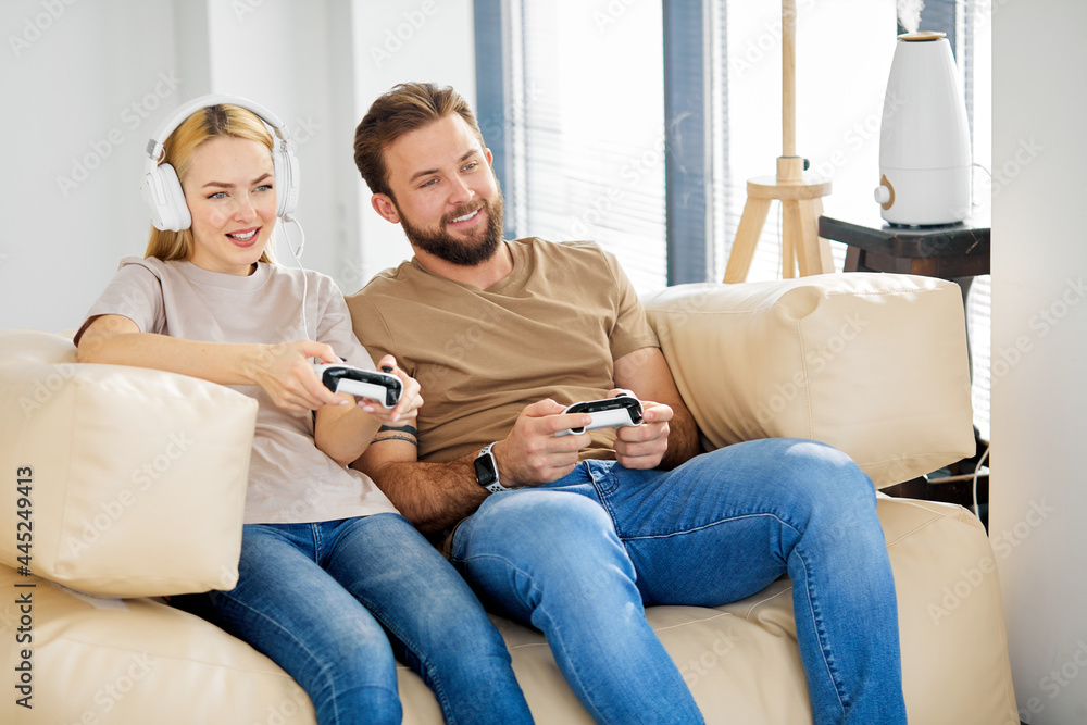 two friends playing video games at home. Lifestyle and technology concept. Portrait of funny comic couple holding joy sticks in hands playing video game enjoying activity sitting on sofa indoors two friends playing video games at home. Lifestyle and technology concept. Portrait of funny comic couple holding joy sticks in hands playing video game enjoying activity sitting on sofa indoors