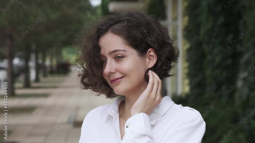 Beautiful smiling confident young brunette with curly hair, beautiful face posing on street. Happy young woman in shirt, professional girl posing. Portrait of adorable smiling woman outside
Beautiful smiling confident young brunette with curly hair, beautiful face posing on street. Happy young woman in shirt, professional girl posing. Portrait of adorable smiling woman outside