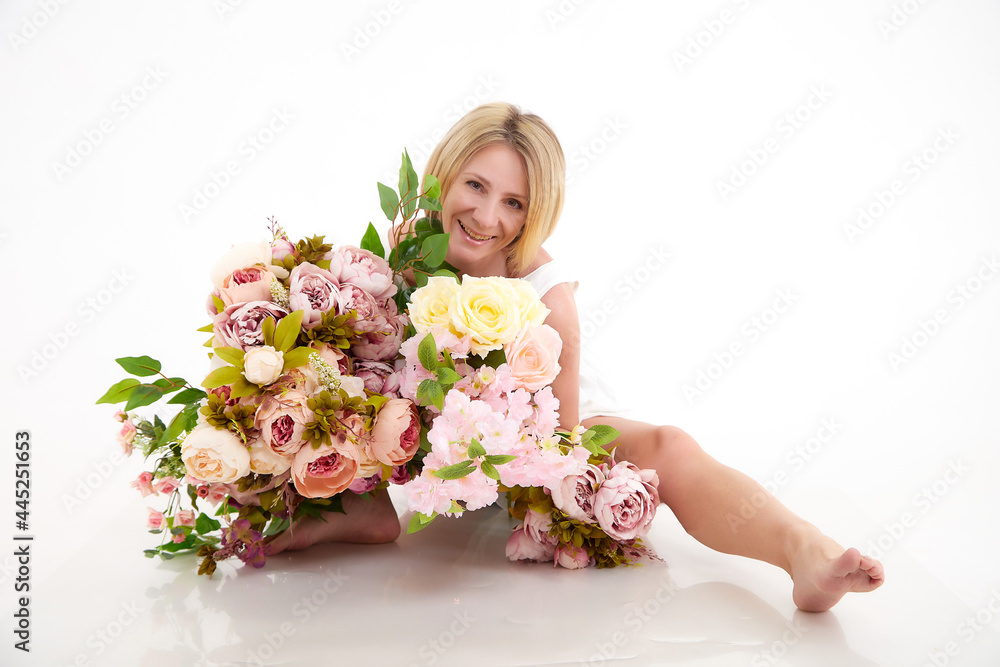 Pretty skinny girl with beautiful flowers on a white background in photo studio Pretty skinny girl with beautiful flowers on a white background in photo studio