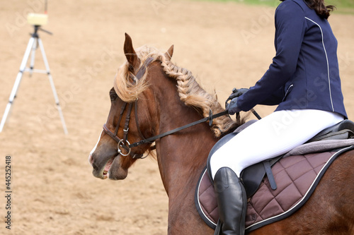 Old leather saddle with stirrups for show jumping race. Equestrian sport event background © acceptfoto