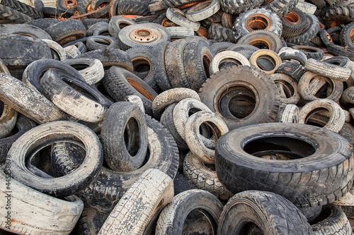 Industrial landfill for the processing of waste tires and rubber tyres. Pile of old tires and wheels for rubber recycling.