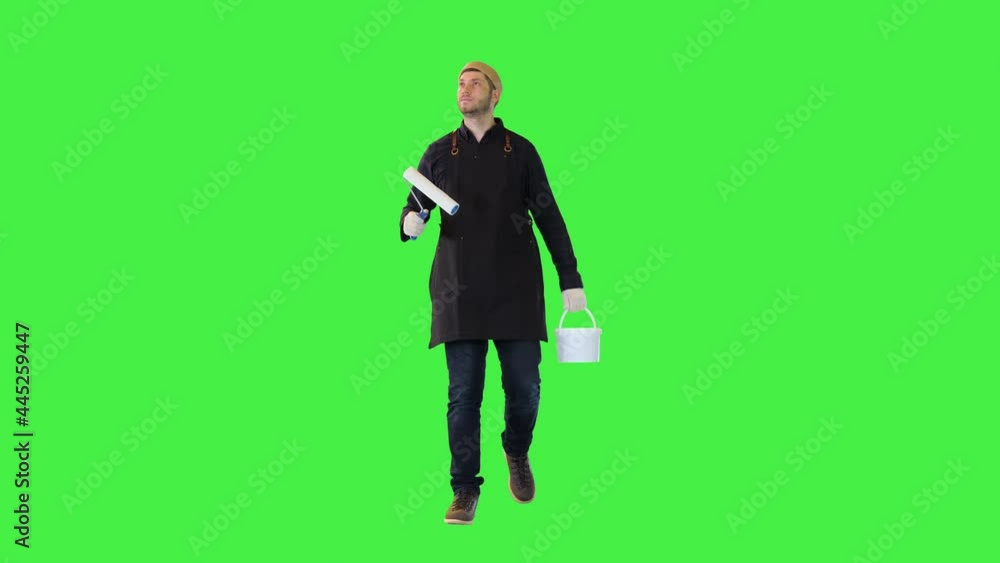Satisfied painter renovation service worker walk with roller, bucket of paint point to painted walls on a Green Screen, Chroma Key. Satisfied painter renovation service worker walk with roller, bucket of paint point to painted walls on a Green Screen, Chroma Key.