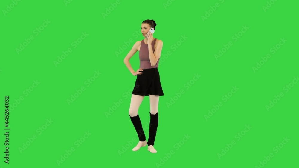 Young ballerina talks on mobile phone, making a little warm-up on a Green Screen, Chroma Key. Young ballerina talks on mobile phone, making a little warm-up on a Green Screen, Chroma Key.