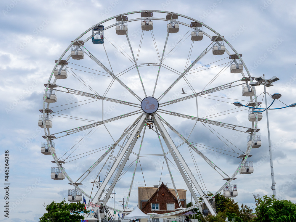 Courseulles-sur-Mer, France July 2021. The great wheel of attraction for tourists by the beach in the port.